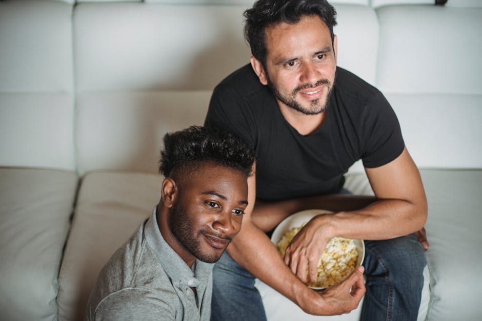 A happy couple relaxing indoors, sharing popcorn and enjoying their time together.