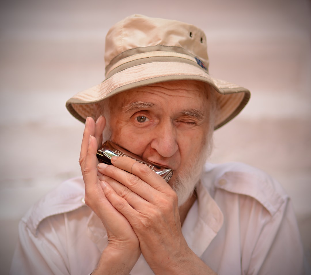 woman in white hat holding black smartphone