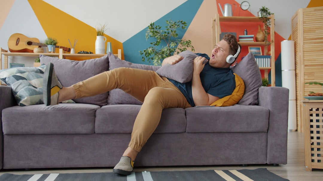 Man listening to music on couch with pillow