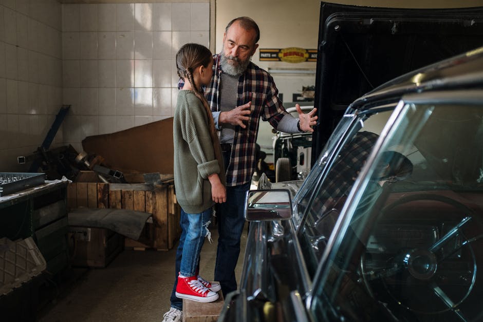 Father teaching daughter about cars in a workshop, showcasing family bonding.