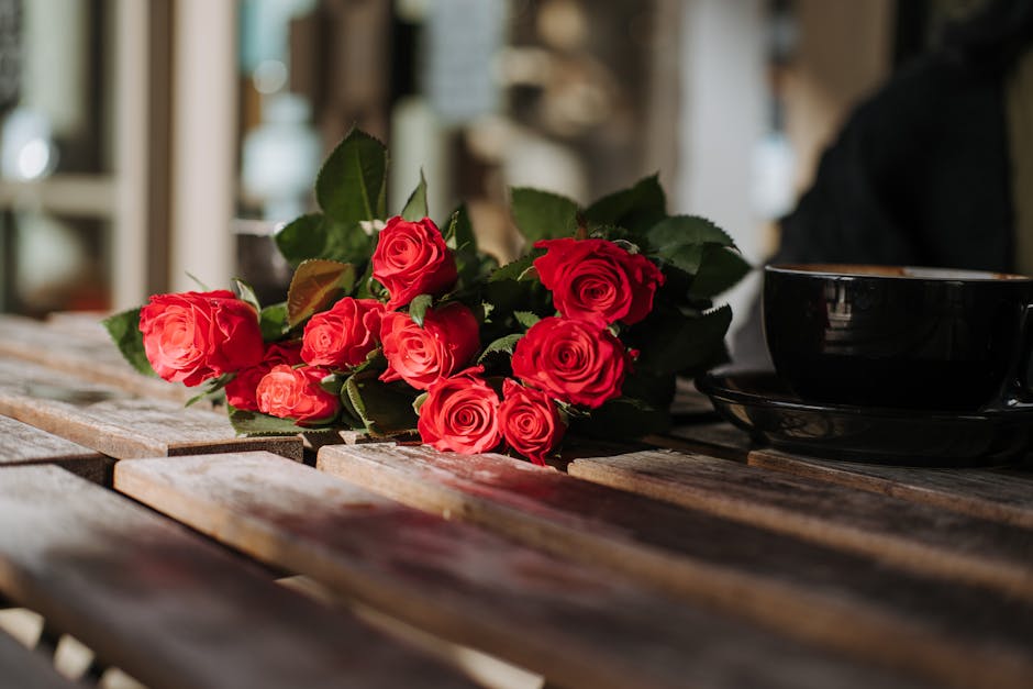 A bouquet of fresh red roses placed on a rustic wooden table, capturing natural beauty and elegance.