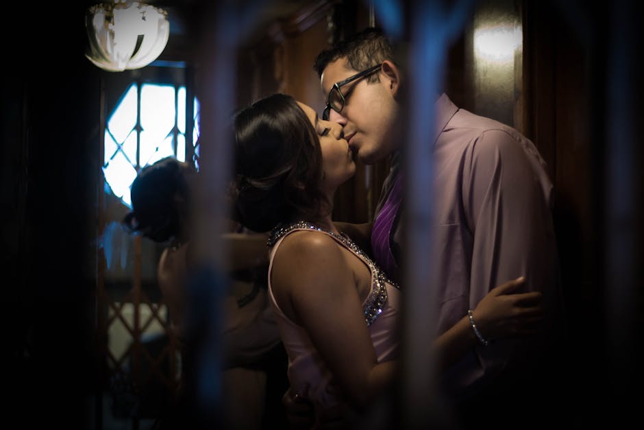 A couple sharing an intimate moment in a dimly lit, cozy indoor setting.