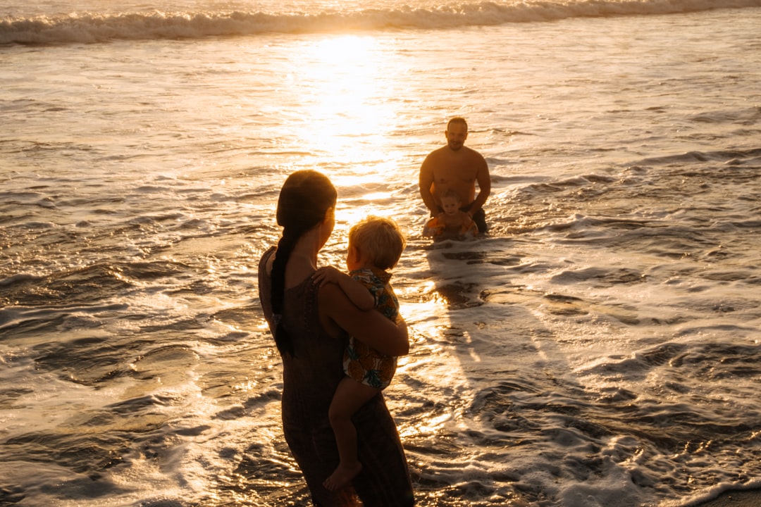 Family playing in the ocean at sunset