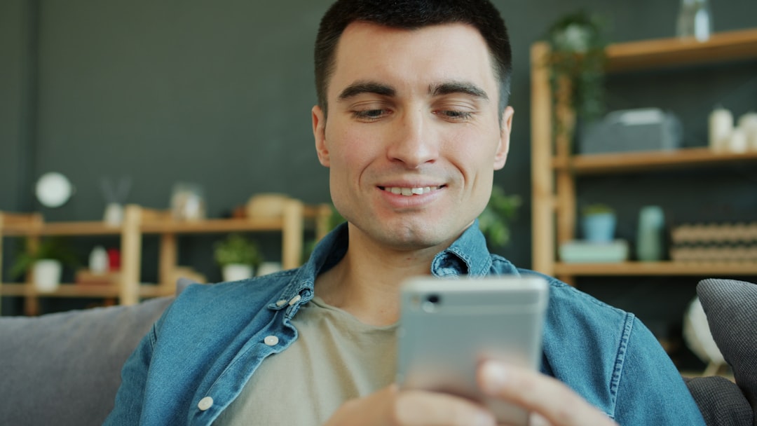 Man smiling while looking at his smartphone