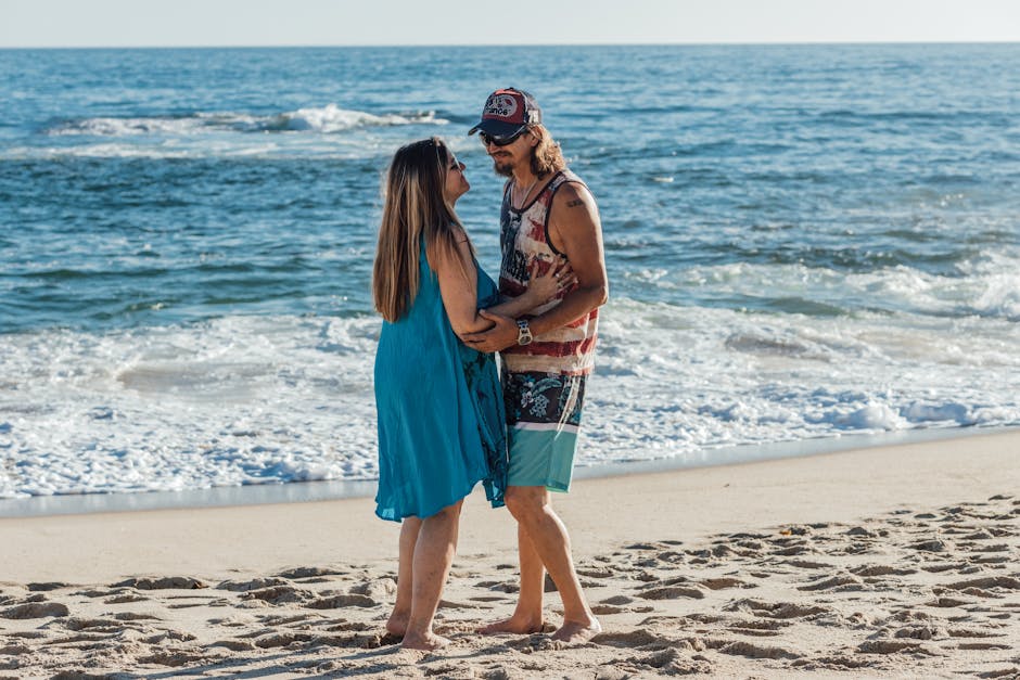 Senior couple enjoys a romantic stroll on a sunny beach, embodying love and relaxation.