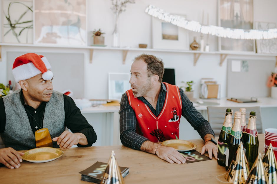 Two men enjoying a festive holiday party at the office with decorations and champagne.
