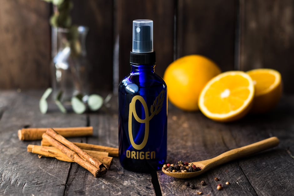 Blue spray bottle with cinnamon, oranges, and peppercorns for aromatherapy.