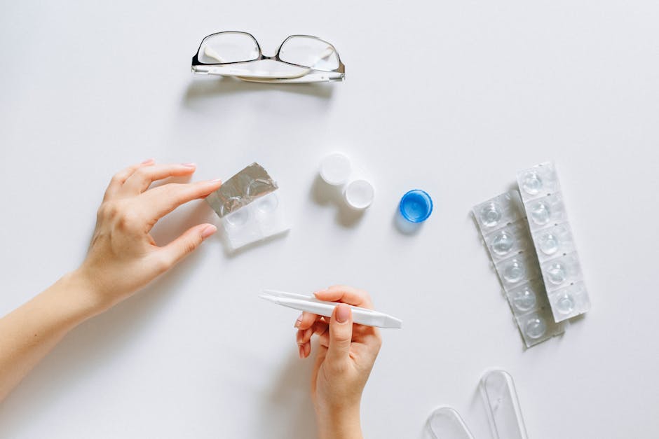 Flat lay setup of contact lenses with eyeglasses for eye care on a white background.